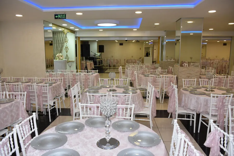 Pembe örtülü masalar ve beyaz sandalyeler